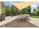 Outdoor patio area with shade sail, dining set, grill, and landscaping at 8833 Maplewood Dr, Highlands Ranch, CO 80126