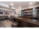 Finished basement features a bar with dark wood accents, custom shelving, and a cozy seating area at 16102 Grebe Pl, Parker, CO 80134