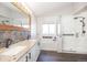 Spa-like bathroom with double sinks, granite countertops, and a glass-enclosed shower, blending luxury and functionality at 16102 Grebe Pl, Parker, CO 80134