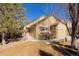 Charming yellow home featuring stone accents, an attached garage, a well-manicured lawn, and an American flag at 16102 Grebe Pl, Parker, CO 80134