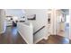 A well-lit upstairs hallway leads to a bathroom and bedroom, showcasing the home's modern design and open layout at 16102 Grebe Pl, Parker, CO 80134