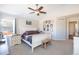 Well-lit bedroom with a white sleigh bed, ceiling fan, and window with green curtains at 16102 Grebe Pl, Parker, CO 80134