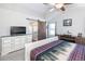 Comfortable bedroom with a large dresser, tv and bathroom with a sliding barn door at 16102 Grebe Pl, Parker, CO 80134