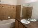 A bathroom features a bathtub with tiled walls and a single sink vanity with a wood cabinet and a large mirror at 14400 Albrook Dr # 88, Denver, CO 80239