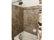 This bathroom includes a shower/tub combo, brown tile and a shower curtain at 14400 Albrook Dr # 88, Denver, CO 80239
