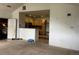 Open living room with tan carpet flowing into the adjacent kitchen with wood cabinets at 14400 Albrook Dr # 88, Denver, CO 80239