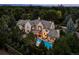 Expansive property with a pristine pool, outdoor lounging area, and surrounding mature trees; Denver skyline in distance at 27 Polo Club Cir, Denver, CO 80209
