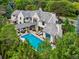 Aerial view of a stunning home with a pool and meticulously designed outdoor living space surrounded by lush greenery at 27 Polo Club Cir, Denver, CO 80209