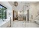 Bathroom with a luxurious soaking tub, marble shower, vanity, and herringbone tile floors at 27 Polo Club Cir, Denver, CO 80209