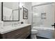 Bathroom featuring a modern vanity, framed mirror, decorative sconces, and a glass-enclosed tub-shower combination at 27 Polo Club Cir, Denver, CO 80209