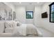 Minimalist bedroom with white bedding, modern art, a flat-screen television, and views of the outdoors at 27 Polo Club Cir, Denver, CO 80209