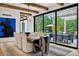 Bright dining room with modern chandelier, wooden beams, and doors to outdoor living space and pool at 27 Polo Club Cir, Denver, CO 80209