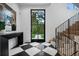 Grand foyer with black and white tile, modern staircase, and a large window looking out to the yard at 27 Polo Club Cir, Denver, CO 80209