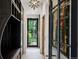 Hallway with coat racks and storage leading to backyard; natural light and starburst light fixture at 27 Polo Club Cir, Denver, CO 80209