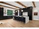 Elegant kitchen with a spacious island, bar seating, and custom dark wood cabinetry against light hardwood floors at 27 Polo Club Cir, Denver, CO 80209
