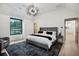 Spacious bedroom with neutral tones, a modern light fixture, and views of the outdoors at 27 Polo Club Cir, Denver, CO 80209