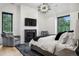 Bedroom with fireplace, accent chairs, and large windows offering natural light and scenic views at 27 Polo Club Cir, Denver, CO 80209