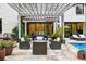 Inviting outdoor patio with stylish seating, built-in grill, and tranquil pool views under a pergola at 27 Polo Club Cir, Denver, CO 80209