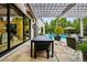 Outdoor patio with stylish furniture, a built-in barbecue, and views of the lush backyard and pool at 27 Polo Club Cir, Denver, CO 80209