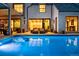 Elegant home with a stunning pool area, inviting lounge chairs, and beautifully illuminated outdoor space at 27 Polo Club Cir, Denver, CO 80209