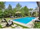 Serene backyard oasis featuring a sparkling pool, comfortable lounge chairs, and lush landscaping at 27 Polo Club Cir, Denver, CO 80209