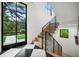 Staircase with hardwood steps, iron railings, black and white tile flooring, and a large window at 27 Polo Club Cir, Denver, CO 80209