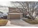 Two-story house with brown siding, attached garage, and a small front porch at 5313 S Malaya Way, Centennial, CO 80015