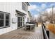 Outdoor deck with a table, chairs, and a white house with dark window trim at 2020 Teller St, Lakewood, CO 80214