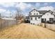 View of backyard, showing lawn, privacy fence, deck and stylish white home exterior with black trim at 2020 Teller St, Lakewood, CO 80214