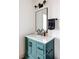 Modern bathroom featuring a teal vanity with a white countertop, black hardware, and a rectangular mirror at 2020 Teller St, Lakewood, CO 80214