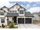 Striking two-story home featuring white siding, black trim, and a two-car garage at 2020 Teller St, Lakewood, CO 80214