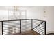 Hallway overlooking a foyer with a modern chandelier, black railings and hardwood floors at 2020 Teller St, Lakewood, CO 80214