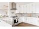 Well-lit kitchen with white cabinets, marble countertops, and stainless steel appliances at 2020 Teller St, Lakewood, CO 80214