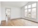 Bright room with large windows, wood floors, and an adjacent doorway to another room at 2020 Teller St, Lakewood, CO 80214