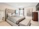 Stylish bedroom with tufted headboard, decorative art, and a mirrored dresser at 7865 E Mississippi Ave # 1501, Denver, CO 80247