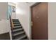 Indoor stairwell with carpeted steps and brown door at 10211 Ura Ln # 7-108, Thornton, CO 80260