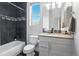 Modern bathroom with sleek vanity, dark tile accents, and a bright window at 12497 W Virginia Ave, Lakewood, CO 80228