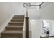 Carpeted staircase with a wooden handrail and white risers, leading to the upper level at 12497 W Virginia Ave, Lakewood, CO 80228