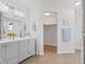 Elegant bathroom with double vanity, contemporary lighting, and a doorway to a walk-in closet at 306 N 14Th Ave, Brighton, CO 80601