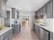 Modern kitchen featuring sleek gray cabinets, stainless steel appliances, and a dining area in the background at 306 N 14Th Ave, Brighton, CO 80601