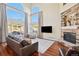 Bright living room with hardwood floors, fireplace, and large windows at 4619 Mohawk Dr, Larkspur, CO 80118