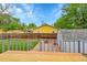 View of deck and fenced yard featuring lush lawn, firepit, storage shed, and mature trees at 1202 9Th Ave, Longmont, CO 80501