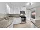 Modern kitchen boasts stainless steel appliances, granite countertops, and tile flooring at 1202 9Th Ave, Longmont, CO 80501