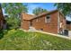 A lush backyard featuring a well-manicured lawn, flower beds, and mature trees at 2654 Forest St, Denver, CO 80207