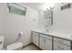 Bathroom featuring white vanity, mirror, and toilet at 2654 Forest St, Denver, CO 80207