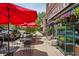 Outdoor seating at Spinelli's Market with red umbrellas, tables, and flowers at 2654 Forest St, Denver, CO 80207