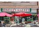Spinelli's Market featuring outdoor tables, umbrella and storefront full of plants at 2654 Forest St, Denver, CO 80207