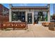 A commercial building with outdoor seating, sidewalk, and barrel table at 2654 Forest St, Denver, CO 80207