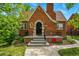Charming brick home with arched doorway, black iron gate, and well-maintained landscaping at 2654 Forest St, Denver, CO 80207