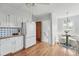 Bright eat-in kitchen with white cabinets, charming breakfast nook, and hardwood floors at 2654 Forest St, Denver, CO 80207